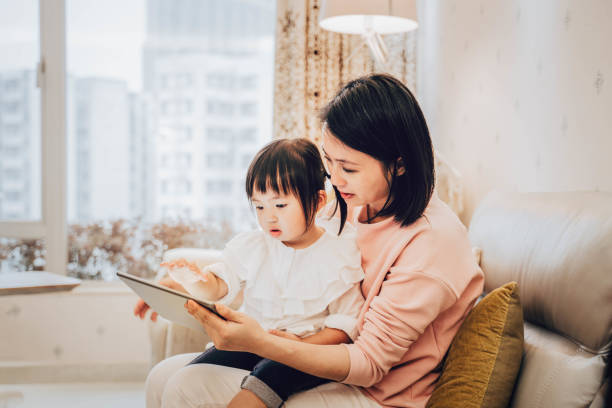 chinese mother and daughter using digital tablet - parent mother music listening imagens e fotografias de stock