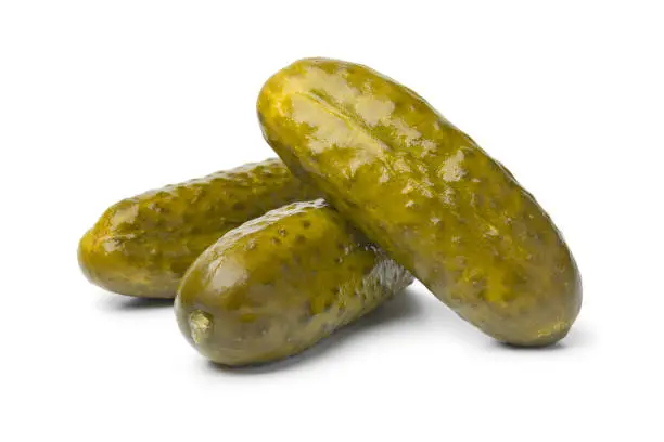 Whole pickled gherkins close up on white background