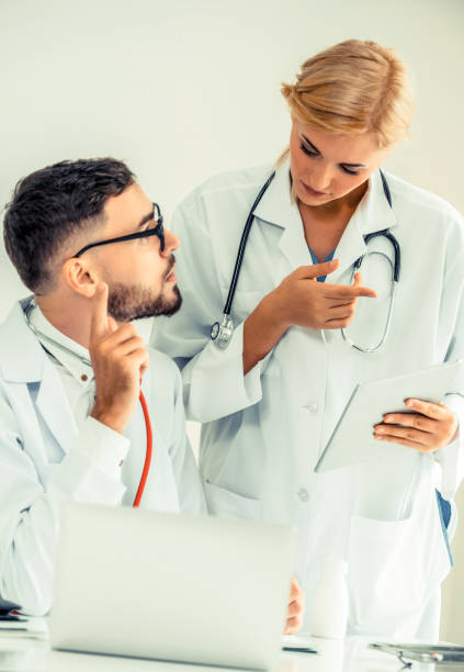 istock Doctor at hospital office working on laptop computer on the table with another doctor having discussion about patients health. 1134711084