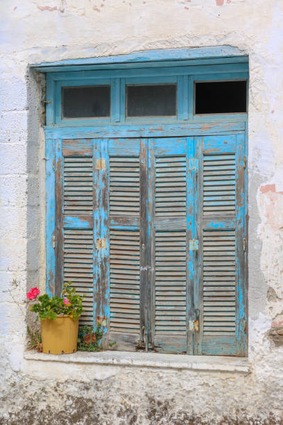 istock closed shutters at an old window with flowers, Paros, Greece 1134714215