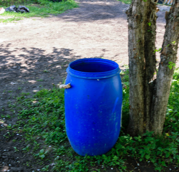 Blue plastic barrel for water in the spring fruit garden