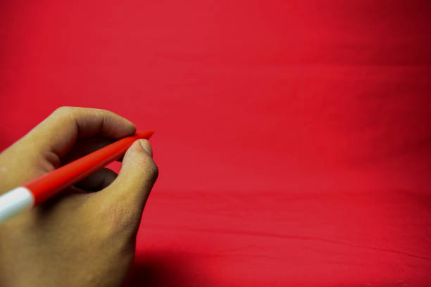 Happy Chinese New Year, Hand of young female asian woman in red casual t-shirt with gesture of her hand holding Chinese Red envelopes isolated on the pink background.