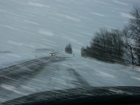 Heavy snow drifting across the road