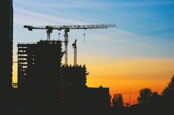 Construction house at dusk evening yellow light, blue sky, crane