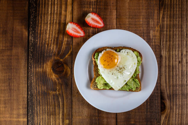 istock Toast with avocado and egg in heart shape and strawberries 1134729696