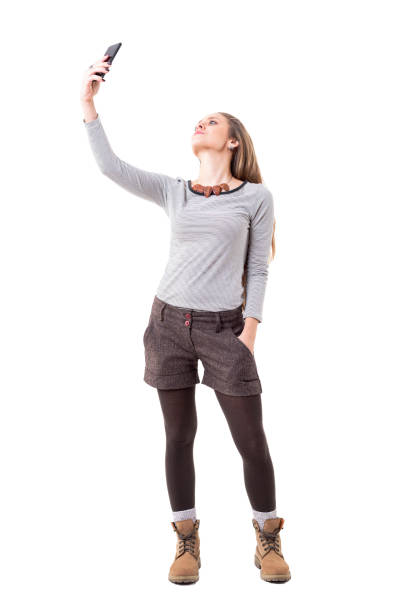 istock Cool relaxed young stylish hipster girl taking selfie with smartphone from high angle 1134731611