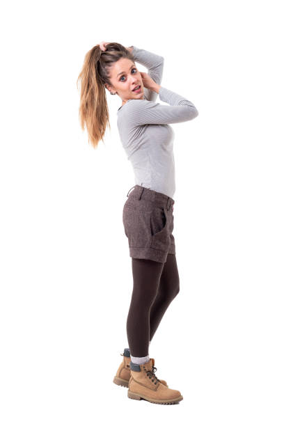 istock Beautiful young woman stylish cutie holding hair in pony tail and posing for camera 1134731752