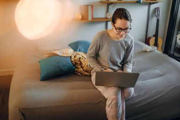 Photo of teenager girl using laptop in a room