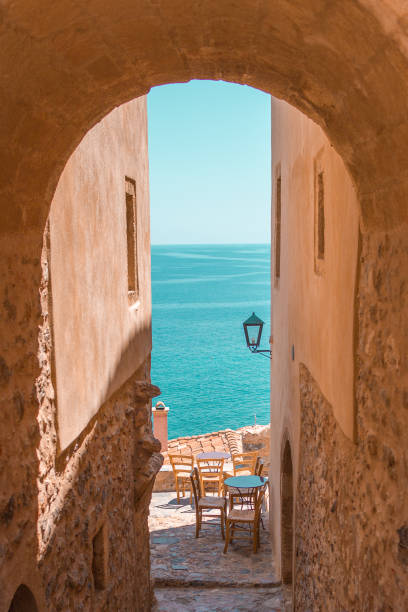 Hello Sea View A pathway in Monemvasia leading to a peaceful seaside view monemvasia stock pictures, royalty-free photos & images