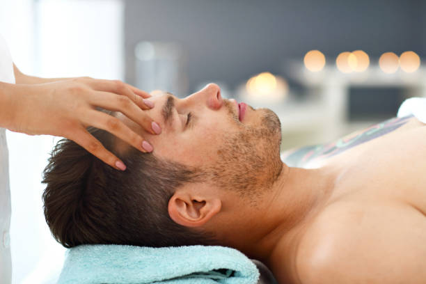 homme bel ayant le massage dans le salon de spa - lastone therapy spa treatment massaging massage therapist photos et images de collection