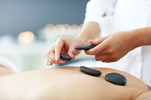 homme bel ayant le massage dans le salon de spa - lastone therapy spa treatment massaging massage therapist photos et images de collection