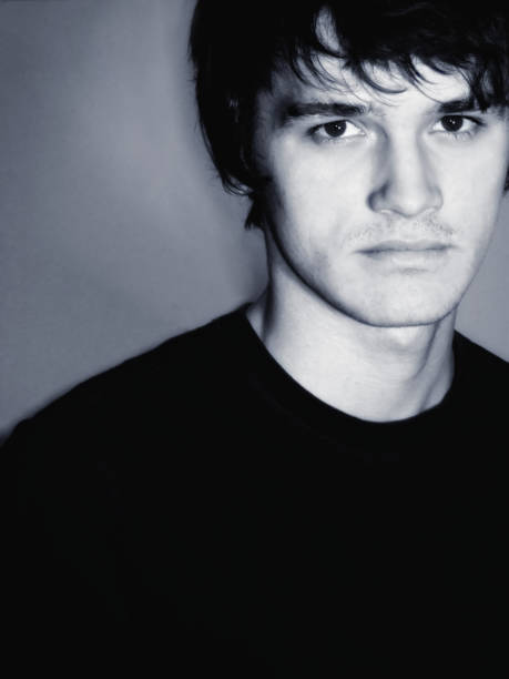 istock Portrait Of Serious Young Man Standing Against Wall 1134746579