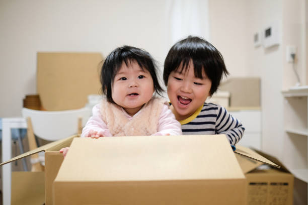 istock Toddler and baby opening cardboard box 1134748116