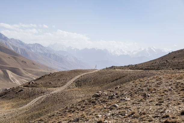 pamir highway dans le paysage désertique des monts pamir au tadjikistan. l'afghanistan est sur la gauche - pamirs photos et images de collection
