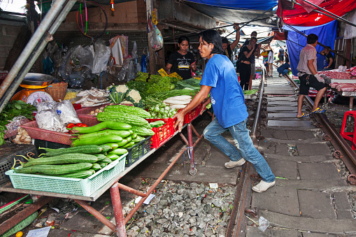 Shopkeepers move goods off the tracks while the train is coming in the Maeklong Railway Market, a local market commonly called Siang Tai (life-risking) Market. Spreading over a 100-metre length, the market is located by the railway near Mae Klong Railway Station.