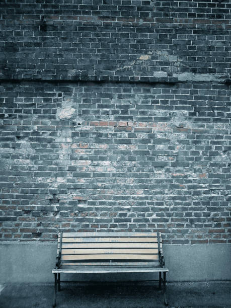 isolated couple seat in front of a brick wall