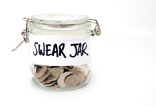 Swear jar with coins in on a white background