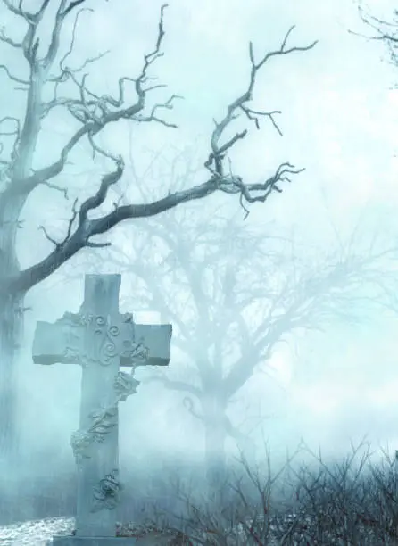 Photo of a scary graveyard with gravestone,a cross symbol and dried up trees