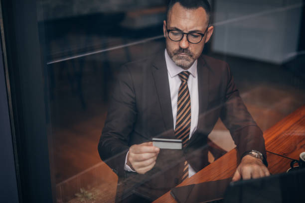 istock Elegant senior man is using credit card to pay online 1134757772