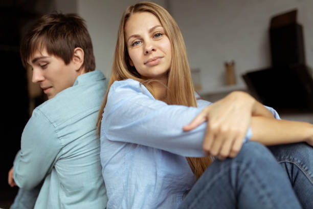 istock Young lovely couple sitting on the table back to back 1134758323