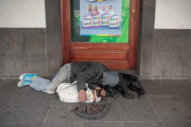 Funchal, Madeira, Portugal - February 17, 2019: Homeless man sleeping in the street in Funchal the biggest city on the island Madeira. A popular tourist destination in the Atlantic ocean.