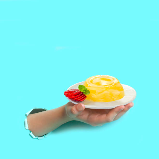 istock Hand is holding plate of pineapple jelly through torn paper 1134759564