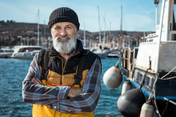 Fisherman Portrait of senior fisherman in front of sea fisherman stock pictures, royalty-free photos & images