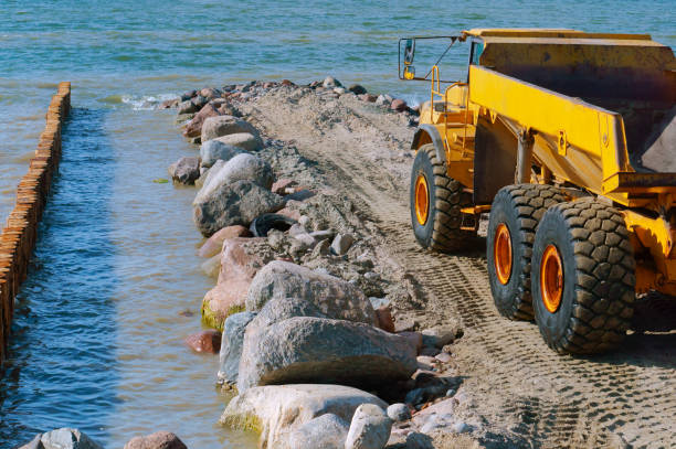 construction of breakwaters, construction equipment on the sea coast stock photo