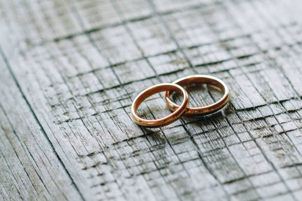 istock Two wedding rings on a wooden texture 1134762518