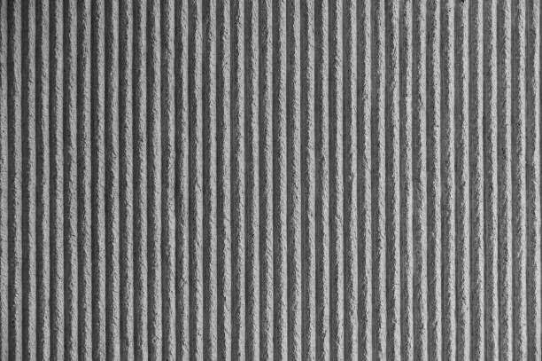 Surface of the wall with a decorative white plaster. Textured concrete wall with vertical lines and stripes as a texture or background. Repair, design concept. - Image