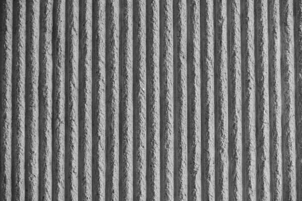 istock Surface of the wall with a decorative white plaster. Textured concrete wall with vertical lines and stripes as a texture or background. Repair, design concept. - Image 1134785917
