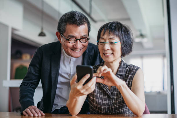 couple chinois gai utilisant le smartphone - chinese ethnicity men old china photos et images de collection