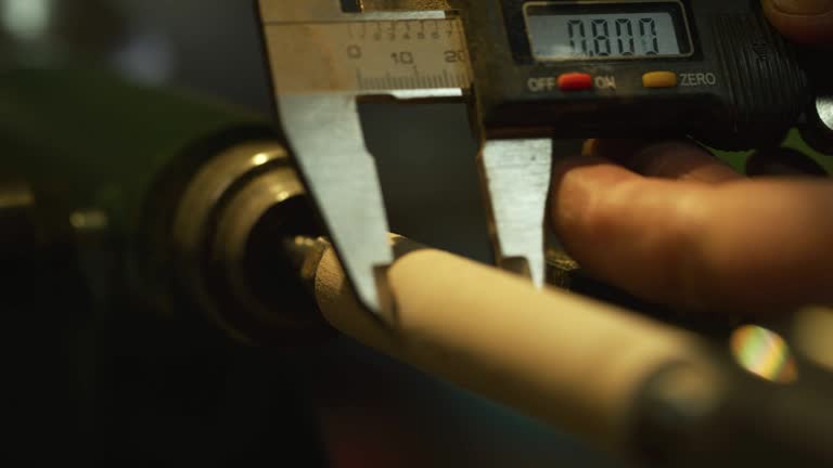 A Man Uses a Micrometer to Measure the Thickness of a Wooden Dowel on a Lathe
