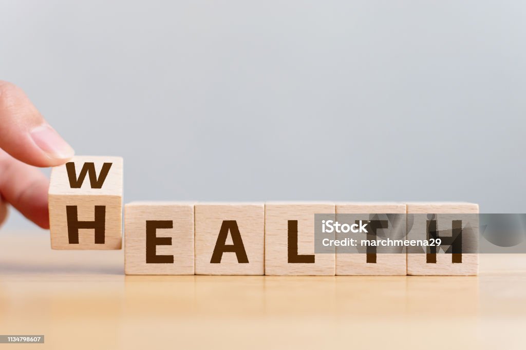 La main Flip cube en bois avec la richesse de mot à la santé. Investissement dans l'assurance-vie et le concept de santé - Photo de Santé et médecine libre de droits