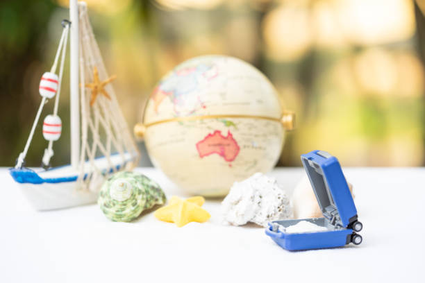 Travel and financial saving concept. Miniature baggage on the sandbox decorating for summer. stock photo