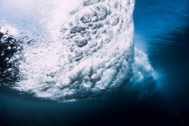 istock Wave underwater with air bubbles and sun light. Ocean in underwater 1134806407