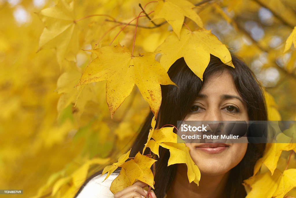 Woman looking through leaves in autumn  Autumn Stock Photo