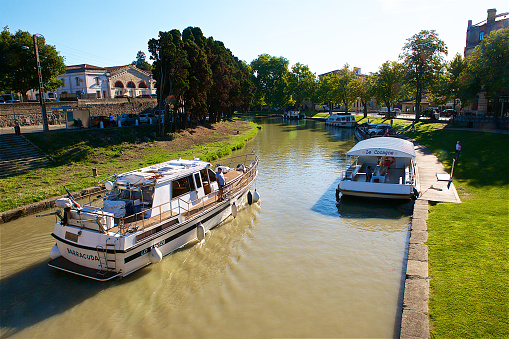 Carcassonne,France-08 20 2015: People on a boat travelling on the Canal du Midi,which is a long canal in Southern France, joining the Garonne river to the Étang de Thau on the Mediterranean.
