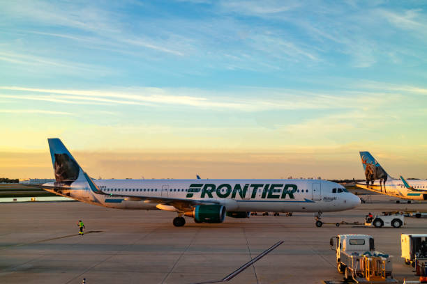 Orlando, Florida, USA - A Frontier Airlines Airplane Is Being Pushed Back To Taxi For Take-Off At Orlando International Airport At Almost Sunset Time stock photo