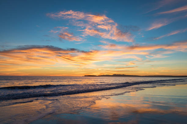 Sunset with colorful sky and reflections in waves. Saturated colors of sunset at Limantour Beach, Pt. Reyes CA. Facing northwest. Reflections in the water and waves. west marin stock pictures, royalty-free photos & images
