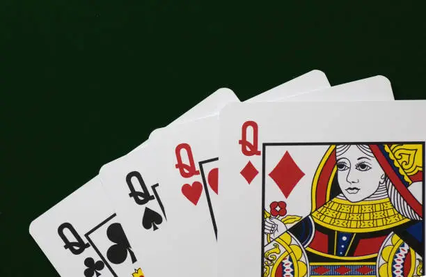four queens playing cards  green felt background