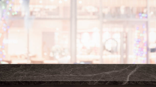 istock Empty black marble stone table top and blurred bokeh cafe and restaurent interior background with vintage filter - can used for display or montage your products. 1134819295