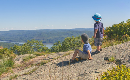 Two young boys look out over the scenic Hudson Valley with the Hudson River Below.