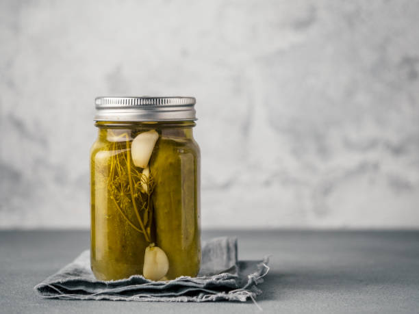 Glass jar with pickled cucumbers, copy space