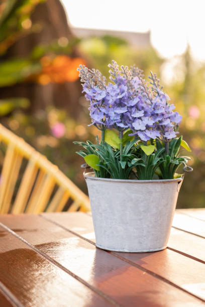 istock Artificial lavender flowers in metal vase on wood table. 1134832296