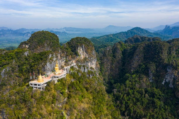 View from above, stunning aerial view of the beautiful Tiger Cave Temple (Wat Tham Sua) surrounded by amazing ridges of limestone mountains. This Buddhist temple is located north of Krabi Town, Thailand. vista desde arriba, impresionante vista aérea del hermoso templo de la cueva del tigre (wat tham sua) rodeado de increíbles crestas de montañas de piedra caliza. este templo budista se encuentra al norte de la ciudad de krabi, tailandia.