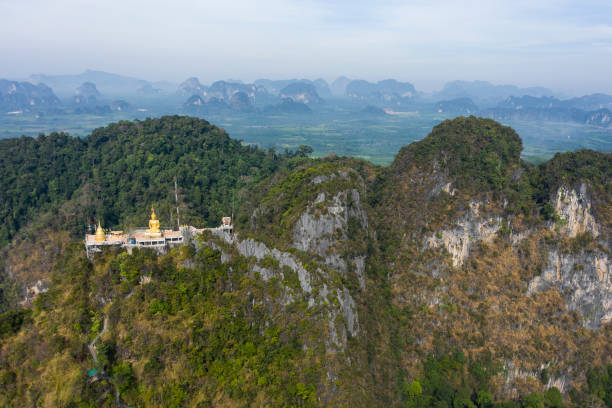 View from above, stunning aerial view of the beautiful Tiger Cave Temple (Wat Tham Sua) surrounded by amazing ridges of limestone mountains. This Buddhist temple is located north of Krabi Town, Thailand. View from above, stunning aerial view of the beautiful Tiger Cave Temple (Wat Tham Sua) surrounded by amazing ridges of limestone mountains. This Buddhist temple is located north of Krabi Town, Thailand. wat tham sua stock pictures, royalty-free photos & images