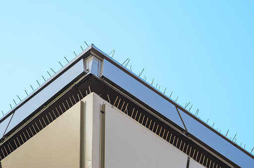 Roof Parapet. Anti-Bird Spikes on Parapet of Modern Building. Spikes for Building Elements Designed Against Bird Landing.