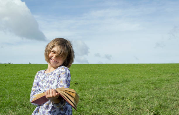 istock Happy girl outdoors reading a book 1134838283