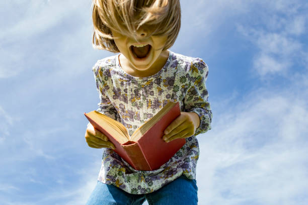 istock Happy girl outdoors reading a book 1134838349